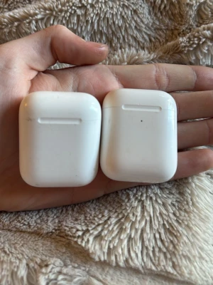 Apple AirPods med laddningsetui - Säljer två par vita Apple AirPods med tillhörande laddningsetui. Den ena är modell 1 och den andra modell 2. Säljer för att dom inte kommer till användning längre. 