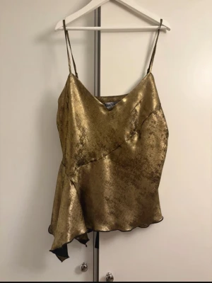 Snyggt linne i guld med volanger  - Helt ny med prislapp, köpt för 18€.