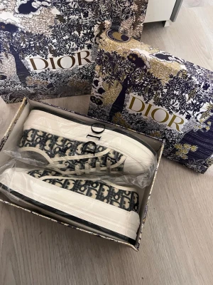 Dior sneakers  - Säljer ett par helt nya  superfina Dior WALK’N sneakers. Modellen är med lite högre sula. Låda och bag medföljer. Storlek 40 men ganska små, de är en klar 39a. Pris går att diskutera, hör av er vid frågor och intresse.