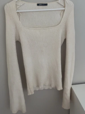 Beige ribbstickad tröja Gina Tricot - Snygg beige/vit ribbstickad tröja från Gina Tricot med fyrkantig ringning och långa ärmar. Tröjan har en figurnära passform och är tillverkad i mjukt stickat material❤️😍