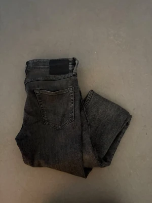 Svarta slim fit jeans - Säljer ett par svarta slim fit jeans med tvättad look och klassisk femficksmodell. Jeansen har normal midja och raka ben. Materialet är denim med en lätt stretch för extra komfort. Perfekta för en avslappnad och trendig stil. Jeansen är använda ett par gånger men fungerar helt felfritt, säljs då de inte används längre. Storlek 29/30! ABS! Pris går att diskutera! 