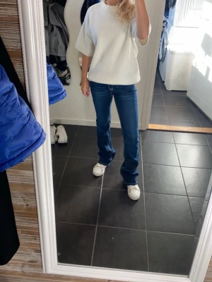 Blå bootcut jeans 💙💙 - Säljer ett par klassiska blå bootcut jeans med mellanblå tvätt och lätt slitna detaljer. Jeansen har normal midja, fem fickor och dragkedja med knapp. Perfekta till sneakers eller boots och ger en avslappnad men snygg look. 