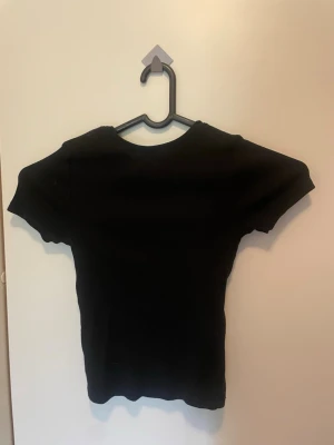 Svart och vit ribbad t-shirt - Två stilrena t-shirts i svart och vitt med ribbad struktur. Klassisk rund halsringning och korta ärmar. Perfekta basplagg till garderoben och passar till det mesta. Materialet känns mjukt och följsamt.