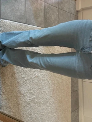 Ljusblå bootcut jeans - Säljer ett par ljusblå bootcut jeans med klassisk femficksdesign och normalhög midja. Jeansen har en avslappnad passform över låren och lätt utsvängda ben. Perfekta för en trendig och avslappnad look. Low waist