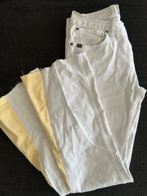 Vita jeans med gula detaljer - Säljer ett par jättefina vita jeans med gul bootcut som jag sytt. Med längden 95 cm, innebenslängd 74,5 och midjemått 74 cm. 