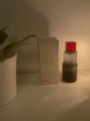 Claiborne parfym  - Claiborne parfym i en frostad glasflaska med svart botten och en fyrkantig röd kork. Flaskan har en modern, stilren design och texten 'claiborne' i rött på framsidan. Förpackningen är randig i vitt och grått för en trendig look. Pris går att diskutera 