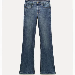 Bootcut jeans - Säljer ett par klassiska blå bootcut jeans. Jeansen har en snygg tvätt  samt röda detaljer vid hällorna. 