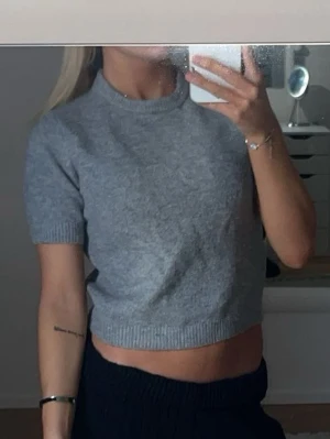 Grå croppad stickad topp - Snygg grå croppad stickad topp med korta ärmar.