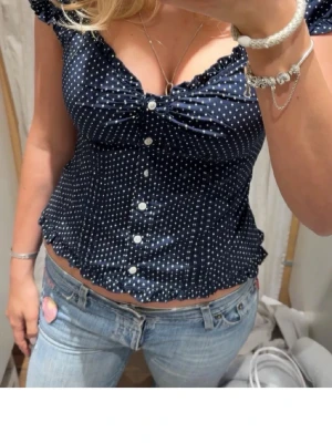 Mörkblå prickig blus med knappar - Supersöt mörkblå blus med vita prickar och knappar. Använd 1 gång och är super söt. Inte min bild!!!!❤️