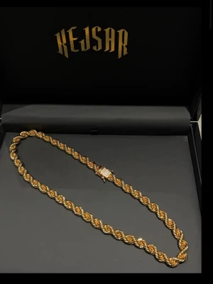 CORDELL HALSBAND 10MM - 18K GULDPLÄTERAD - Handgjord Cordell kedja tillverkad i den slitstarka metallen mässing överdraget med 18K PVD Guldplätering, äkta svenskt guld. Den har kistlås där du kan välja antingen med eller utan diamanter (Moissanite VVS).  65-70 cm  Otroligt fin och massiv kedja som känns väldigt exklusiv, den både ser ut, känns och väger som den ska och det är enligt oss en av våra bästa kedjor.