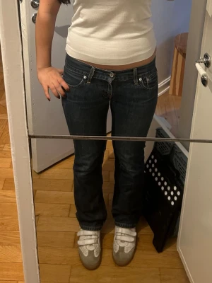 Mörkblå bootcut jeans med låg midja - Säljer ett par mörkblå utsvängda jeans med low waist och klassiska fem fickor. Modellen square eve cut 557, storlek 30/32 men typ en M. Midjemåttet är 40 cm