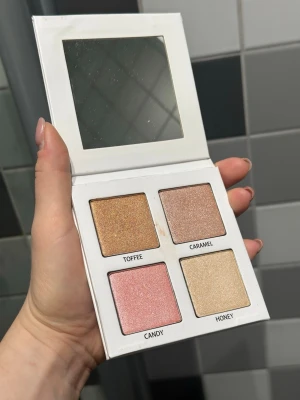Azani Beauty Glow Palette bronser/rouge/highlighter  - Glow Palette från Azani Beauty med fyra skimrande highlighter-nyanser: Toffee (gyllene-brun), Caramel (ljusbrun), Candy (rosa) och Honey (champagne). Paletten är fyrkantig i vit kartong med spegel i locket. Perfekt för att skapa glow och highlighta ansiktet. Har endast swatchat färgerna. 