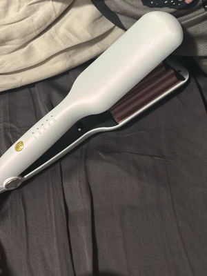 Vit hårvågtång från T3 - Säljer en vit hårvågtång från T3 med breda, roséguldiga värmeplattor. Perfekt för att skapa stora, mjuka vågor i håret. Ergonomisk design och flera värmeinställningar för enkel styling. Sladdanslutning och smidig att använda.