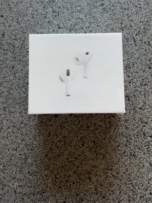 Apple AirPods Pro 3 med USB-C - Trådlösa vita in-ear hörlurar från Apple, modell AirPods Pro 3. Kommer i originalförpackning med laddningsetui och flera örontoppar. Stöd för USB-C, MagSafe och Apple Watch-laddning. Snygg och stilren design i plast. 1:1)