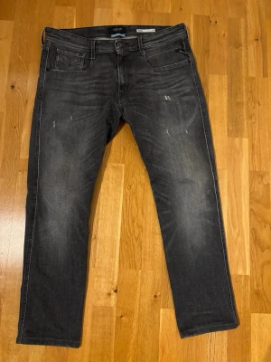 Svarta slim fit jeans från Replay - Snygga svarta slim fit jeans från Replay med slitningar och tvättade detaljer på låren. Sytt upp dem lite i butik men blev lite för mycket så använt max 10 gånger. Passar mellan 165-175cm. Köpta för 1799kr på lokalt jeansbolag. 
