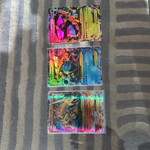 Pokémon GX holografiska samlarkort - Tre Pokémon GX holografiska samlarkort med färgstarka och glansiga motiv. Korten har detaljerade illustrationer och klassisk Pokémon-design på baksidan. Perfekt för samlare eller dig som vill utöka din kortlek.Venusaur,Blastoise och Charizard.