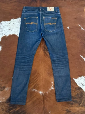 Nudie LeanDean dry Japan selvage - Tjena! Säljer dessa mycket fina nudie i modellen LeanDean dryjapanselvage, byxorna är i storleken W29/L32 och är omsydda lite vid Benöppningen, byxorna är cirka år gammal 10år gamla men är fortfarande otvättade och typ som nya, skick 9/10, bild 4 är exakt samma modell men inte samma par, det är bara så att man ska få en uppfattning om hur fadesen kommer att bli, hör av dig vid funderingar!🙌