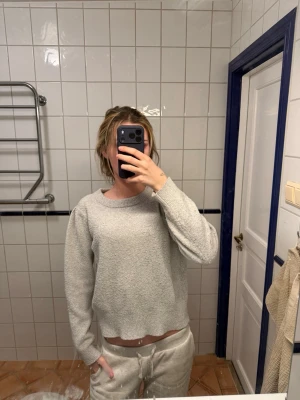 Ljusgrå stickad tröja KappAhl - Mysig ljusgrå stickad tröja från KappAhl i storlek M. Tröjan har rund halsringning, långa ärmar och en mjuk, fluffig struktur som gör den perfekt för kyliga dagar. Enkel och stilren design som passar till det mesta.