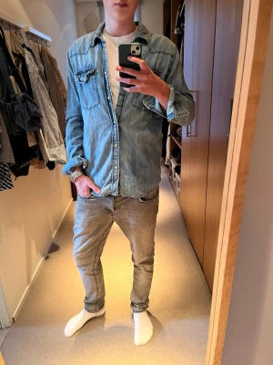 Nudie - jeans skjorta - Tjena, säljer nu denna riktigt feta Nudie jeans skjortan, som är väldigt eftertraktad. Skicket är väldigt bra, skulle säga 9/10. Hög kvalitet och snygga knappar. Stoleken är M, killen på bilden är 182 cm. Släng iväg ett dm för frågor! 🙌🍾