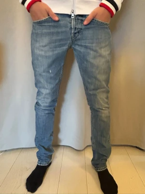 Dondup Jeans - Trendiga Dondup jeans i ljusblå med diskreta slitningar och stilren look. Jeansen har en snygg passform och passar både till vardag och mer uppklädda outfits. Viss tidigare deffekt (Se sista bild) som har fixats därav det fina priset! Skriv gärna vid funderingar!