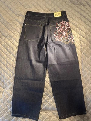 Derschutze jeans Indigo Strl. 34 - streetwear schyze cherry blossom denim baggy jeans - super skick  - Hej! Jag säljer ett par super snygga schyze cherry blossom denim jeans i storlek 34 Baggy design som sitter löst på benen för en snygg streetwear design Cherry blossom design på baksidan ficka Modell: DSE-5087M-3 Kommer från ett djur och rökfritt hem Skickas samma dag! Midja: 90cm.    Innerbenslår: 84cm