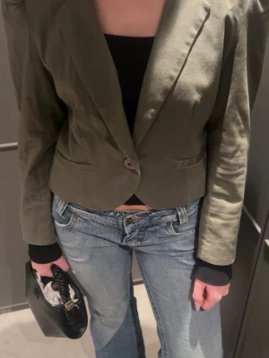 Olivgrön vår blazer/ kappa - Figursydd olivgrön blazer/ kappa, perfekt nu till våren! 🦢Markerade axlar & enkelknäppning framtill. Köpt vintage (finns inget märke lapp borta), storlek s (lapp borta) ☁️
