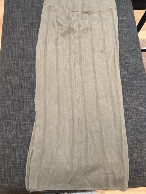 Grön ribbad långkjol - Snygg grön långkjol med ribbad struktur och stretchig midja. Kjolen har en rak passform och är gjord i ett mjukt, tunt material som känns skönt mot huden. 