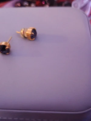 Guldpläterade örhängen med svart sten - Snygga örhängen i guldpläterad metall med rund, svart sten i mitten. Klassisk och stilren design som passar till många olika looks. Stiften är enkla att använda och örhängena har en elegant känsla. Perfekt för dig som gillar minimalistiska smycken.