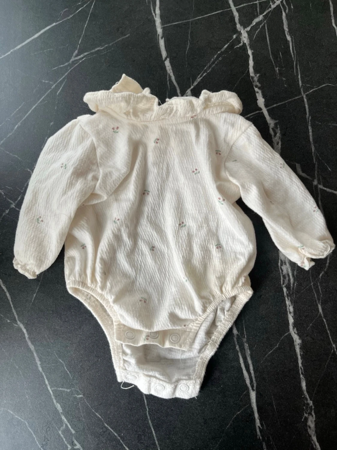 Vit body med volangkrage och små blommor