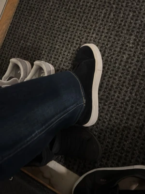 Svarta slip-on sneakers från Eytys - Stilrena svarta slip-on sneakers från Eytys med vit sula och elastiskt band över vristen. Ovandelen är i mockaliknande material och innersulan har korkdetaljer. Perfekta för en clean och modern look. Nästan nya 