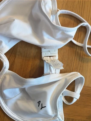 Vit bikini från AsYou - Säljer en vit bikini från AsYou med bygel och justerbara axelband. Bikinin har enkel design utan vaddering och stängs med hakar bak. Tillverkad i ett mjukt och stretchigt material som känns bekvämt mot huden. Säljer då den inte passade mig. Köpt för ett par år sedan inte använd alls. 