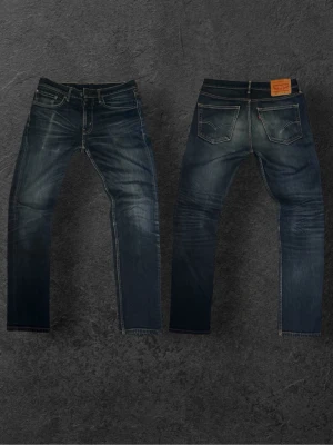 Feta vintage Levi's 511  - Säljer ett par Levi's 511 Slim Jeans i klassisk blå denim med snygg slitning och kontrastsömmar. Jeansen har fem fickor, normal midja och smal passform. Perfekta för en avslappnad men ändå stilren look.