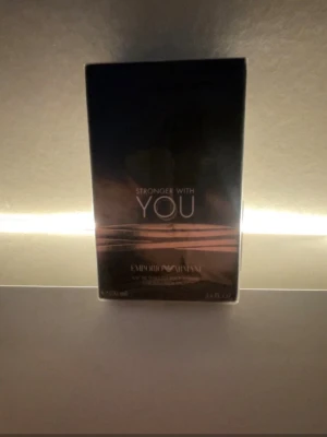 Stronger With You parfym Armani - Stronger With You från Emporio Armani är en elegant parfym i en stilren, mörkgrå och svart förpackning med silverdetaljer. Kartongen har en modern design med blanka och matta ytor. Perfekt för dig som gillar exklusiva dofter och snygg design. Helt ny har inte ens öppnat