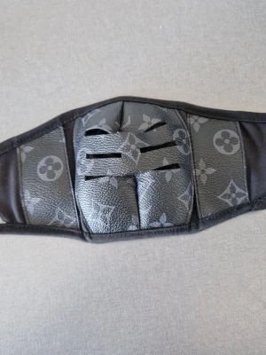 Svart cosplaymask med mönster - Unik svart cosplaymask med klassiskt mönster i grått. Masken har flera ventilationsöppningar framtill och är tillverkad i konstläder och textil. Perfekt för maskerad eller cosplay där du vill sticka ut med en exklusiv look.