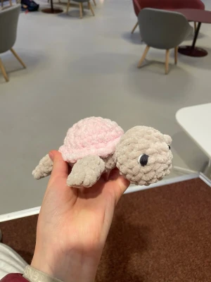 Virkad mjukisturtle i pastellfärger - Supergullig handvirkad sköldpadda med beige hud och rosa skal. Sköldpaddan har svarta broderade ögon vilket gör att den är säker även för små barn, perfekt som dekoration eller gosedjur. Unik och charmig detalj till rummet eller som present.