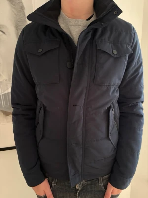 J Lindberg jacka bailey - J.Lindeberg Jacka Bailey – Denimblå – Storlek S  Säljer min J.Lindeberg Bailey jacka. Nypris ca 3500 kr.  Väldigt bra skick, bara använd några gånger. Har mest blivit liggande i garderoben. Sitter snyggt och är enkel att matcha, funkar både till vardags och lite mer uppklätt.  Storlek: S Skick: Mycket bra Nypris: 3500 kr Mitt pris: 2500 kr (pris kan diskuteras)