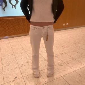 Vita bootcut jeans - bootcut jeans med låg midja, Raka ben med lätt utsvängd passform. Modellen har ett mindre strl så de ser mer löst ut.  Innerbenet 80cm och midjan 37/38cm. Materialet är mjuk och stretchig.