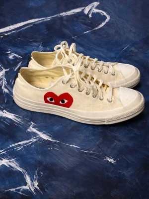 Converse x CDG vita sneakers - Vita Converse x Comme des Garçons Play sneakers med det ikoniska röda hjärtat med ögon på sidan. Skorna är använda fåtalet gånger och är utan slitage. Original box tillkommer såklart. 