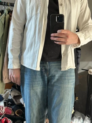 Vit skjorta från Zara med ficka - Stilren vit skjorta från Zara. Skjortan har klassisk krage, knappstängning framtill och en bröstficka på vänster sida. Långärmad modell som passar perfekt till jeans eller chinos för en clean look.