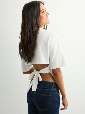 Viral Nelly tie topp  - Trendig vit croppad topp med korta ärmar och öppen rygg som knyts med breda band. Perfekt för dig som vill ha en unik och snygg detalj på din outfit. Passar till både jeans och kjol för en cool look.