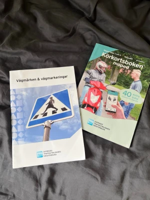 Körkortsboken moped + Vägmärken - Två kursböcker för mopedkörkort: 'Körkortsboken moped' och 'Vägmärken & vägmarkeringar'. Perfekta för dig som pluggar till AM-körkort. Böckerna har färgglada omslag och tydliga illustrationer. Utgivna av STR.