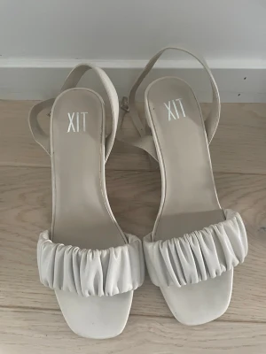 Vita sandaler med klack från XIT - Snygga vita sandaler från XIT. Utmärkt skick, strl 36. Hör av er💕