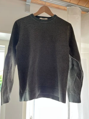 Grå stickad tröja från Selected - Snygg gråmelerad stickad tröja från Selected Homme i storlek S (krympte en del efter första tvätten och sitter mer kokte en XS) med rund halsringning och ribbade muddar vid ärmslut och nederkant. Tröjan har en klassisk rak passform och är perfekt för lager på lager. Materialet känns mjukt och bekvämt.