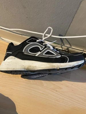 Svarta  sneakers med vit sula - Snygga svarta sneakers med vit och grå detaljrik sula. Skorna har vita och grå detaljer på ovandelen, meshpaneler för extra andningsförmåga och en chunky retroinspirerad siluett. Klassisk snörning.