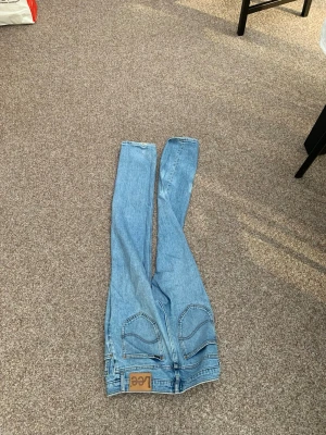 Ljusblå Lee jeans med raka ben - Säljer ett par klassiska ljusblå jeans från Lee med raka ben och hög midja. Jeansen har tydliga sömmar, två bakfickor och Lee-lapp bak i midjan. Tillverkade i bomull för en skön och avslappnad känsla. W29 L32