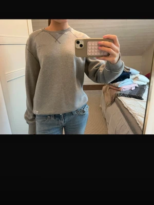 Grå sweatshirt peak performance  - Säljer en vintage och snygg grå sweatshirt från peak performance. Tröjan har rund halsringning, ribbade muddar vid ärmslut och nederkant samt diskret logga på bröstet. Den här slitage vid muddarna. 