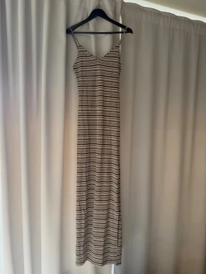 Klänning  - Långklänning från Nelly med slit på ena sidan. Aldrig använd, endast provad hemma en gång. Säljer på grund av kommer inte till användning. Nypris 399 kr