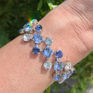 Mixed sized armband kristaller  - Armband med blandade kristaller i tre rader, egen design. Ss 29 6mm, ss39 8mm. Silverpläterad mässing. Färg, Provance Lavender, Tanzanite och Clear Crystal. Längd 21cm inkl lås och förlängningskedja. Sista bilderna visar andra färger på armband. Jag skickar endast spårbart med post nord, samfraktar. Besök gärna mina övriga annonser.  Till mina smycken använder jag kristaller från Preciosa, Aurora och Swarowski.