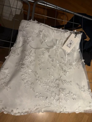 Vit blommig kjol - Supersöt vit kjol med blommigt mönster. Från bikbok som kostar 459 ny, aldrig använd med lapp kvar