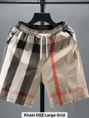 Beige rutiga shorts med snörning - Snygga shorts i beige med stora rutor i svart, vitt och rött. De har elastisk midja med vit snörning och sidofickor. Perfekta för sommaren och har en modern, avslappnad stil. Materialet känns lätt och bekvämt.